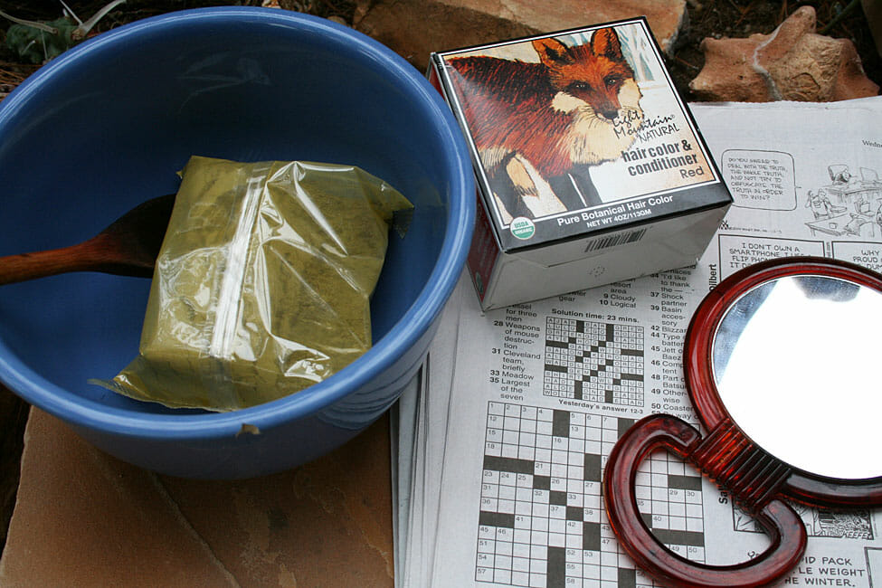 Light Mountain Henna in red with mirror, newspaper, bowl, and wooden spoon.