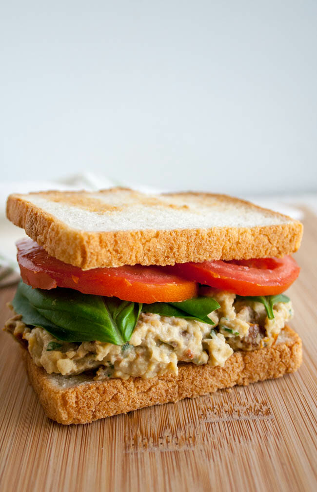 Sun-Dried Tomato and Basil Chickpea Salad Sandwich on cutting board.