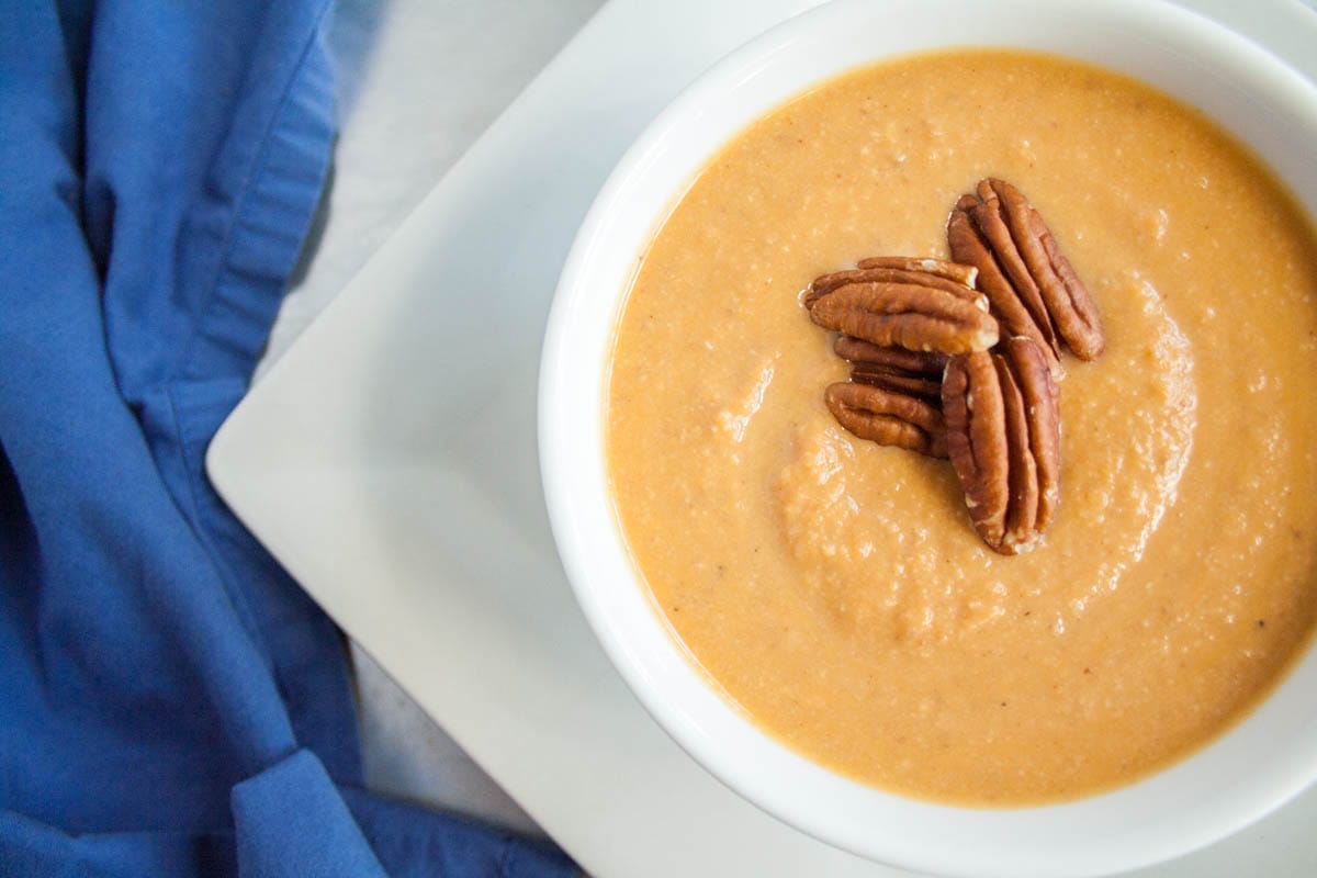 This rich Sweet Potato Soup with Toasted Pecans is Thanksgiving in a bowl! Made in 35 minutes, it is an easy weeknight meal. (vegan, gluten free) Sweet Potato Soup with Pecans in a bowl.
