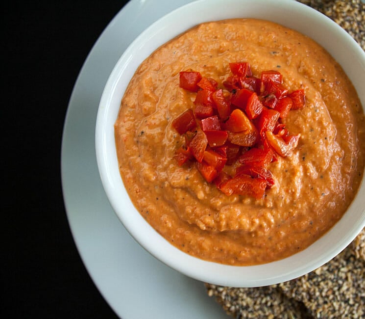 Roasted Red Pepper Hummus with crackers close up.