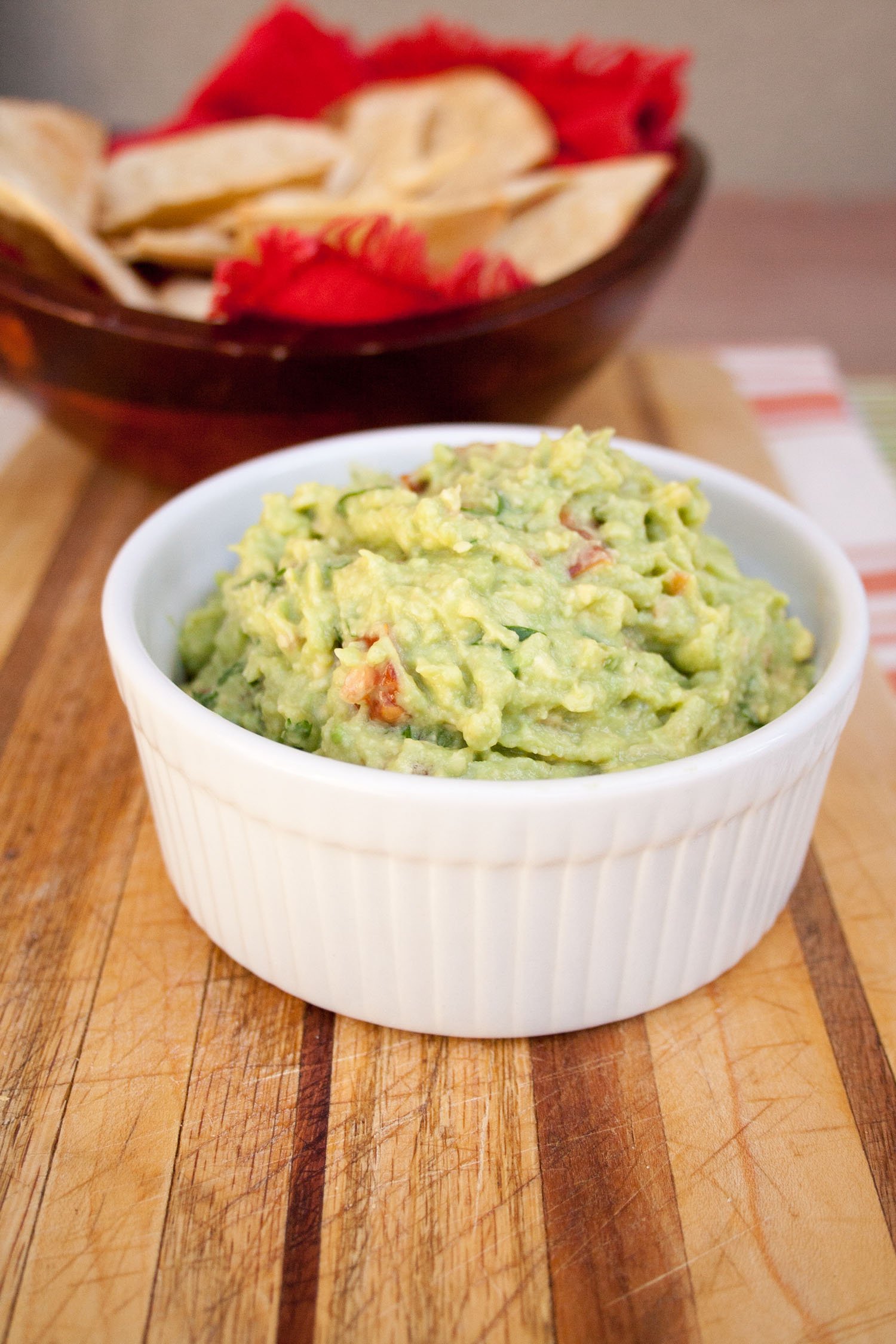 Guacamole with Baked Tortilla Chips in the background.