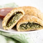 Spinach and Tofu Ricotta Calzones on a plate with marinara sauce.