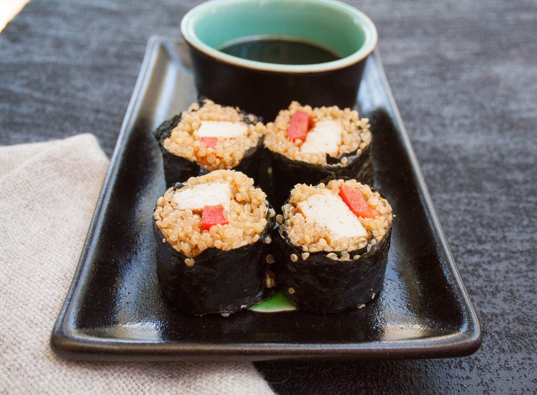 Tofu Sushi Rolls with Quinoa close up with dipping sauce.