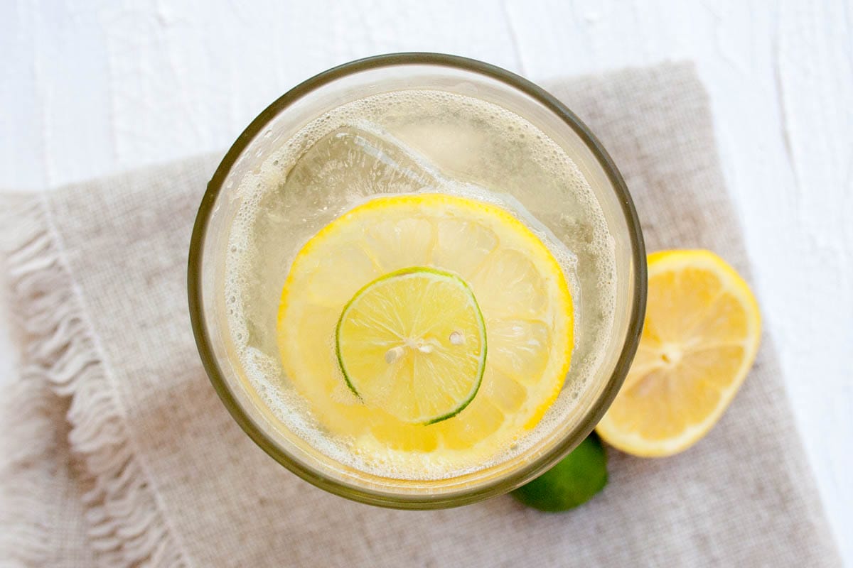 Easy Homemade Lemon Lime Soda - This soda can be made in minutes, and it tastes much better than store bought! Homemade Lemon Lime Soda in a glass with lime and lemon.