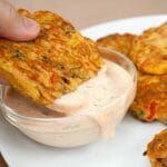 Vegetable Fritter being dipped into vegan chipotle ranch dressing.