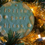 Follow Your Bliss polymer clay ornament hanging on Christmas tree.