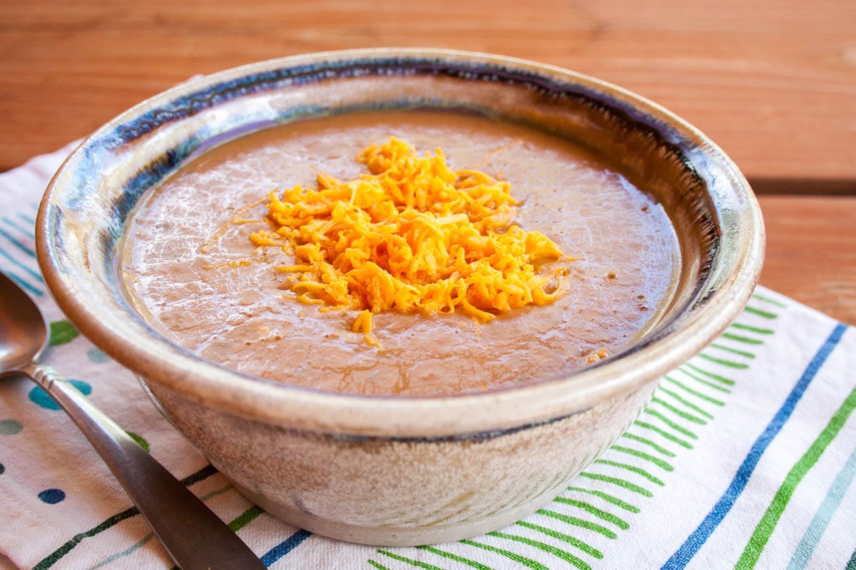 3 Ingredient Refried Bean Soup in a bowl with a spoon.