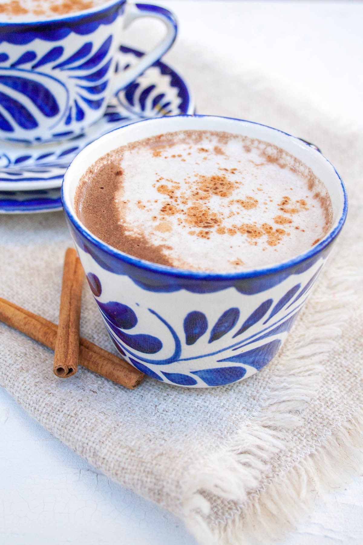 Vegan Mexican Hot Chocolate in two mugs with cinnamon sticks.