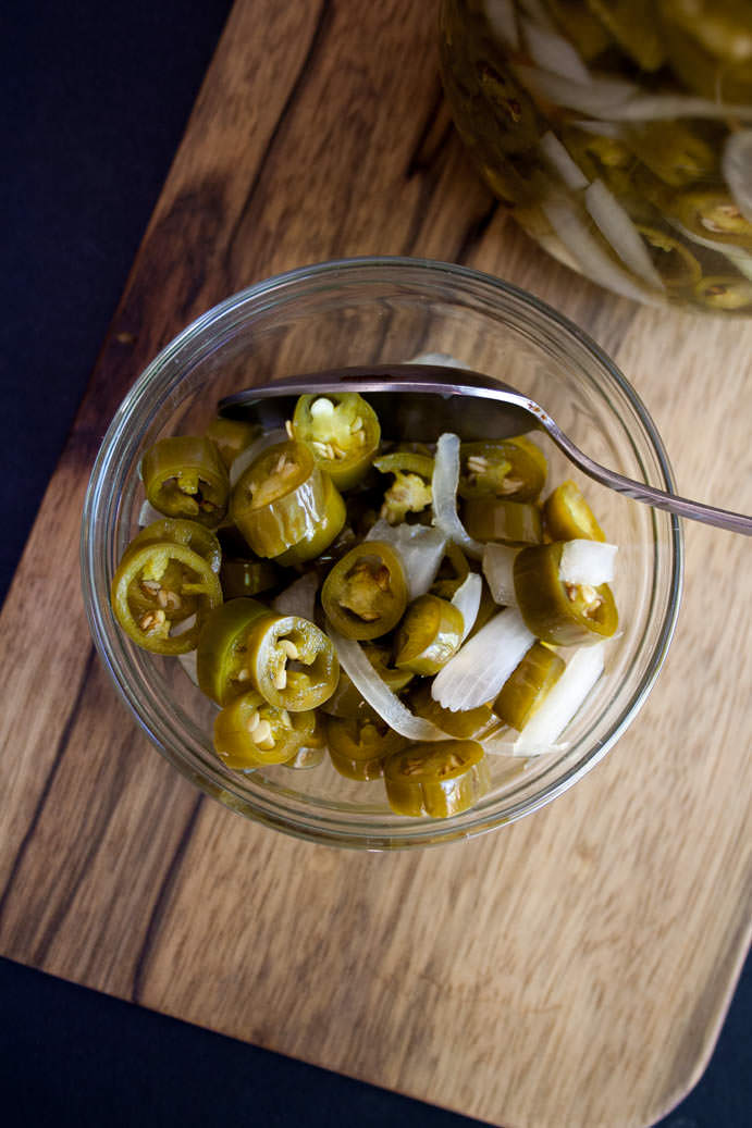 Pickled Peppers and Onions in a bowl with spoon bird's eye view.