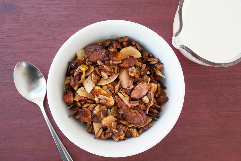 Grain Free Granola with pitcher of almond milk and spoon bird's eye view.