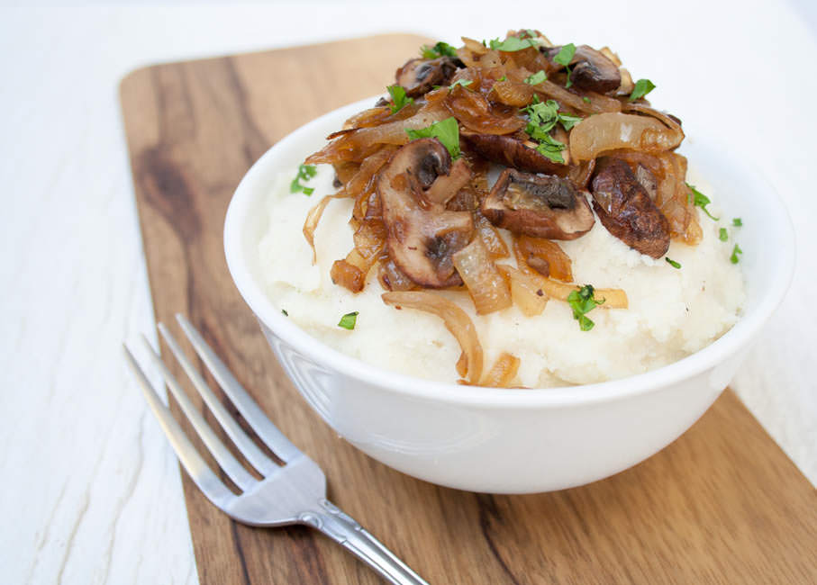 Vegan Mashed Cauliflower with Caramelized Onions and Mushrooms with a fork.