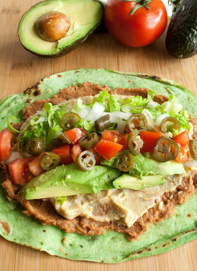 Open faced Vegan Refried Bean Burrito on a cutting board.