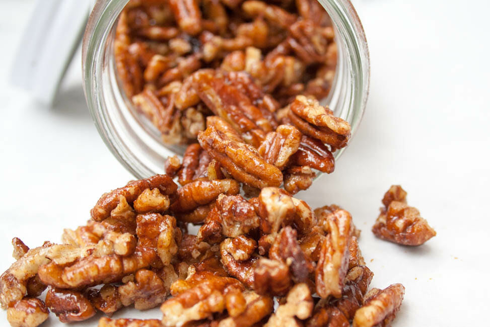 Candied Pumpkin Pie Spice Pecans spilling out of a jar.