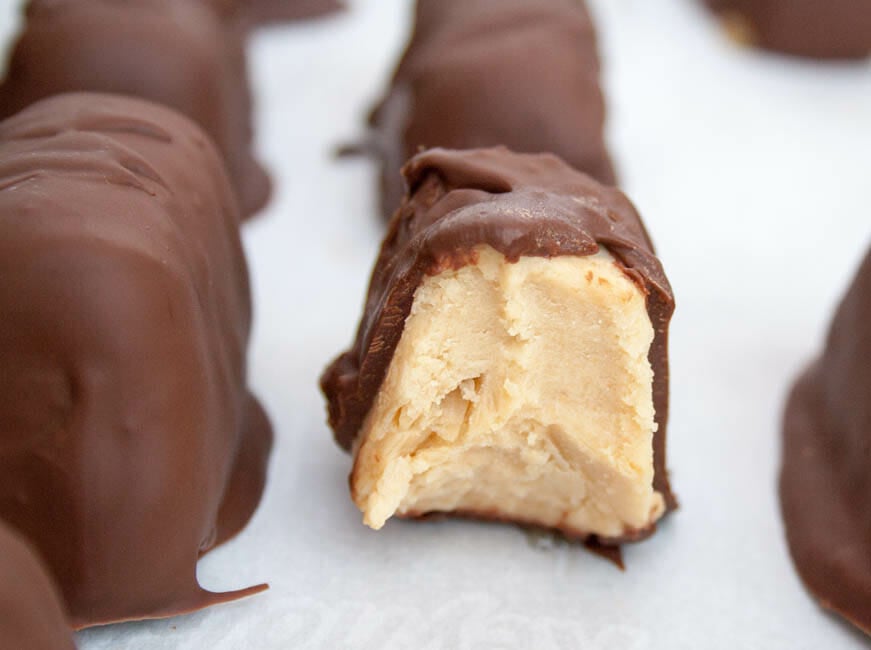 Chocolate Covered Peanut Butter Frozen Yogurt Bites with one that has a bite out of it.