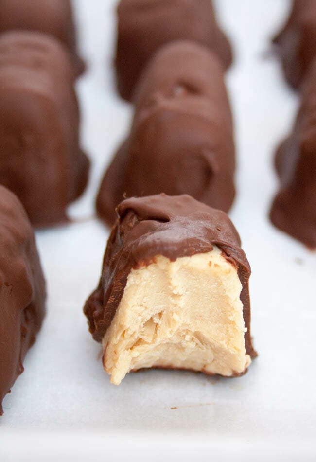 Chocolate Covered Peanut Butter Frozen Yogurt Bites lined up with the one in front with a bite out of it.