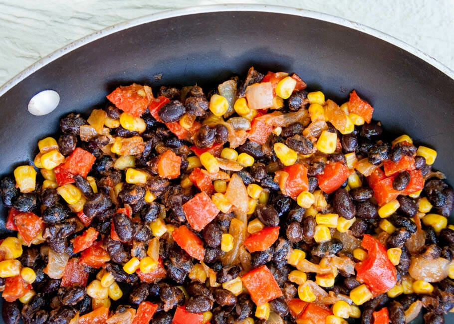 Black beans, corn, red peppers, and onion in a pan after cooking.