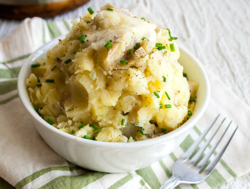 Vegan Roasted Garlic Mashed Potatoes with Almond Milk close up in a bowl with fork.