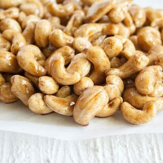 Foolproof 5 Minute Spiced Candied Cashews on. parchment paper.