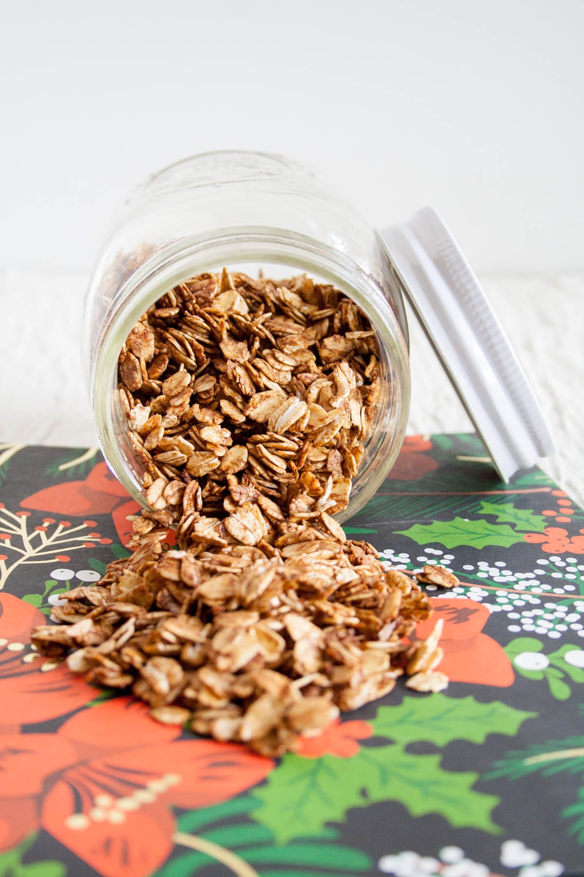 Gingerbread Granola spilling out of a mason jar.