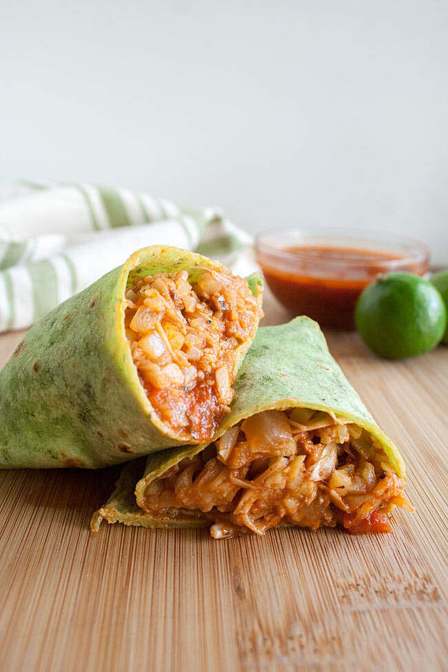 Jackfruit and Cauliflower Rice Burrito cut in half on a cutting board.