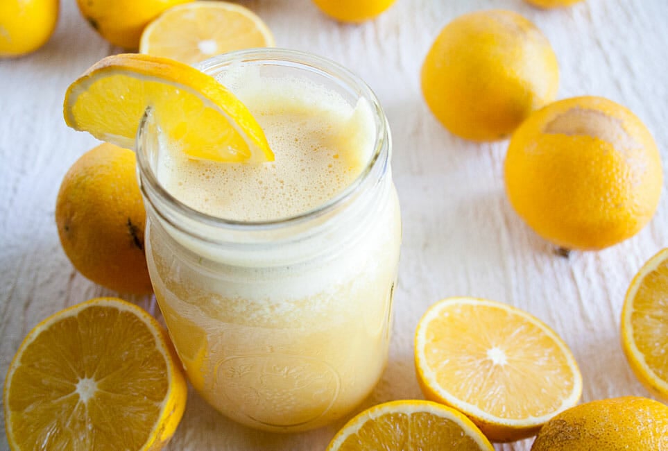 Healthy Homemade Orange Julius in a mason jar with oranges.