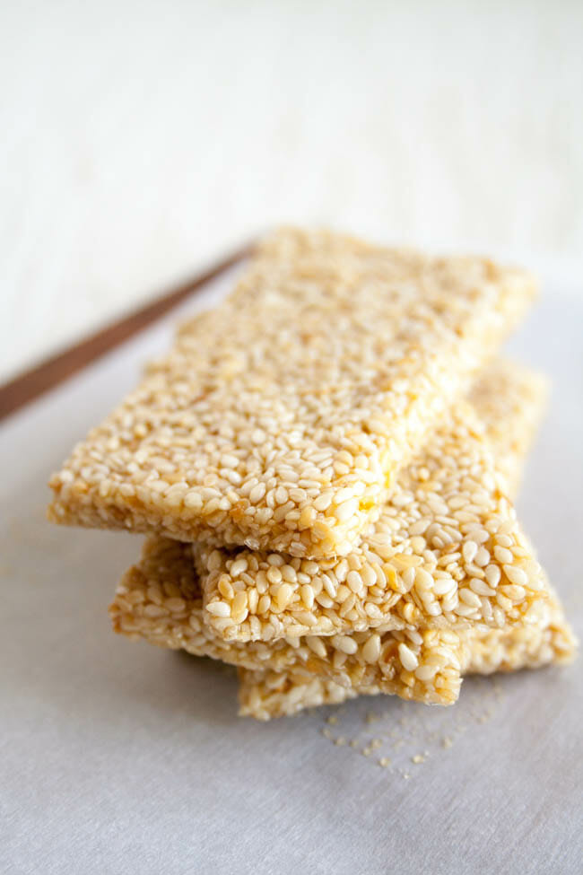 Sesame Seed Bars stacked on parchment paper.