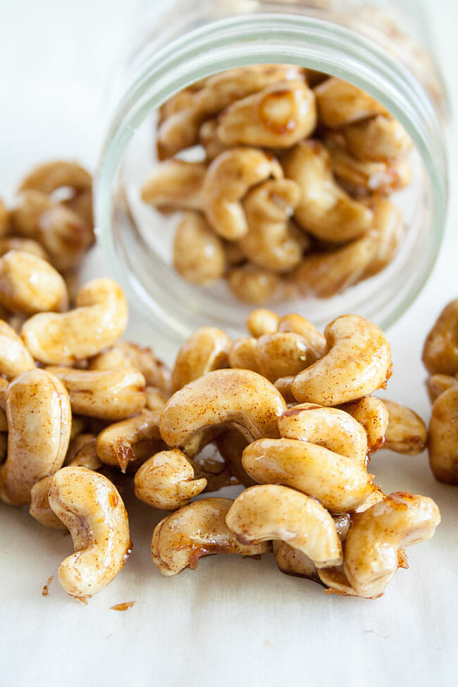 Foolproof 5 Minute Spiced Candied Cashews spilling out of a mason jar.