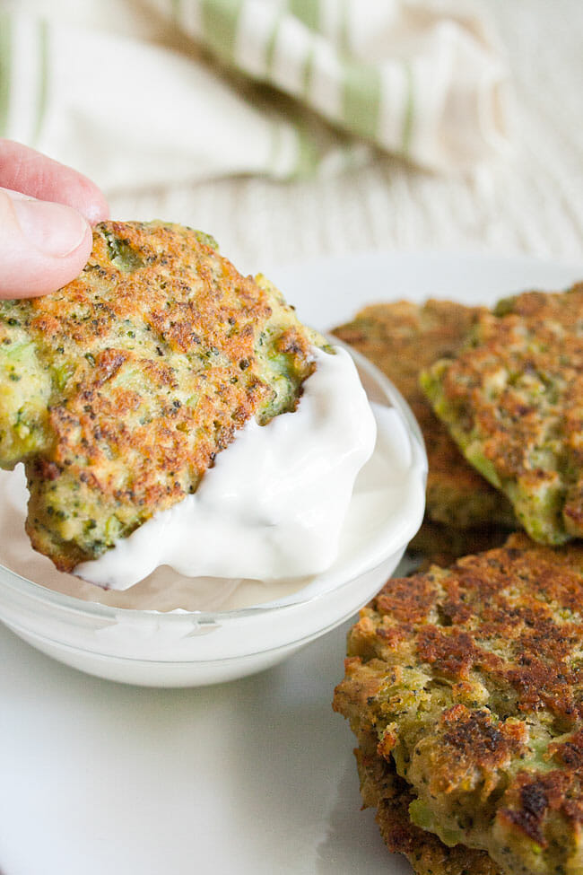 Broccoli Fritter being dipped in a dipping sauce.