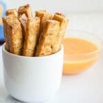 Sriracha Baked Tofu Fries on a plate with dipping sauce.