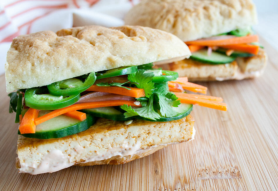 Tofu Bánh Mì sliced in half on a cutting board.