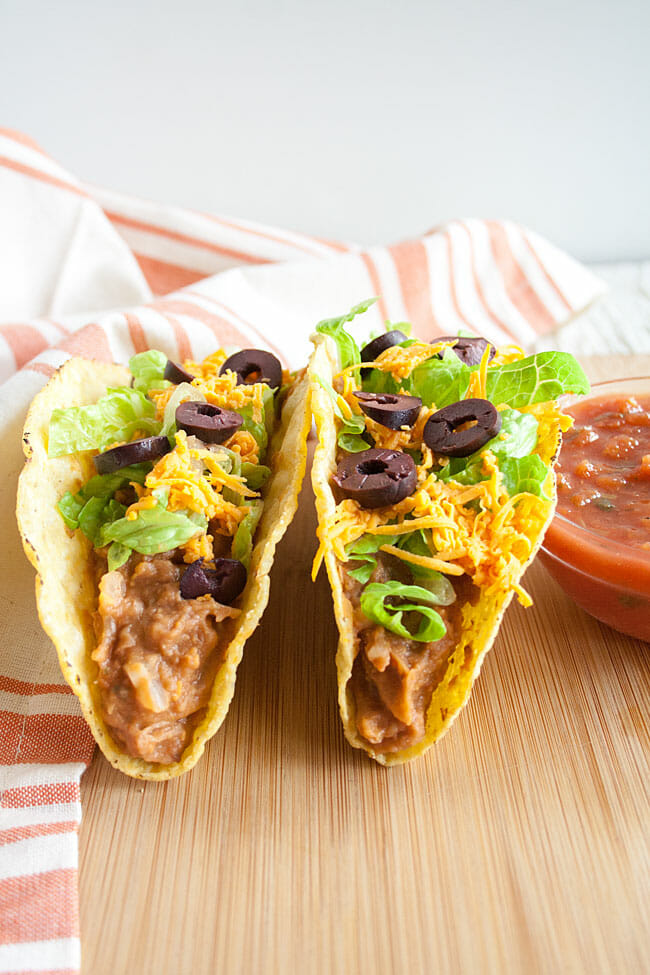 Refried Bean Tacos on a cutting board with salsa.