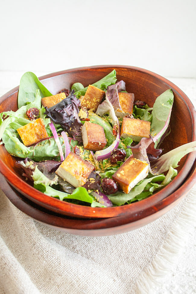 Salad with tofu in wooden bowl.