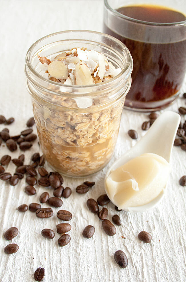 Thai Coffee Overnight Oats with coffee in background and spoonful of sweetened condensed coconut milk.