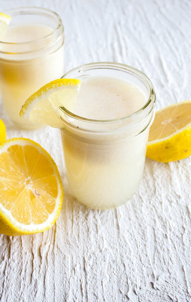 Coconut Lemonade in mason jars with lemons nearby.