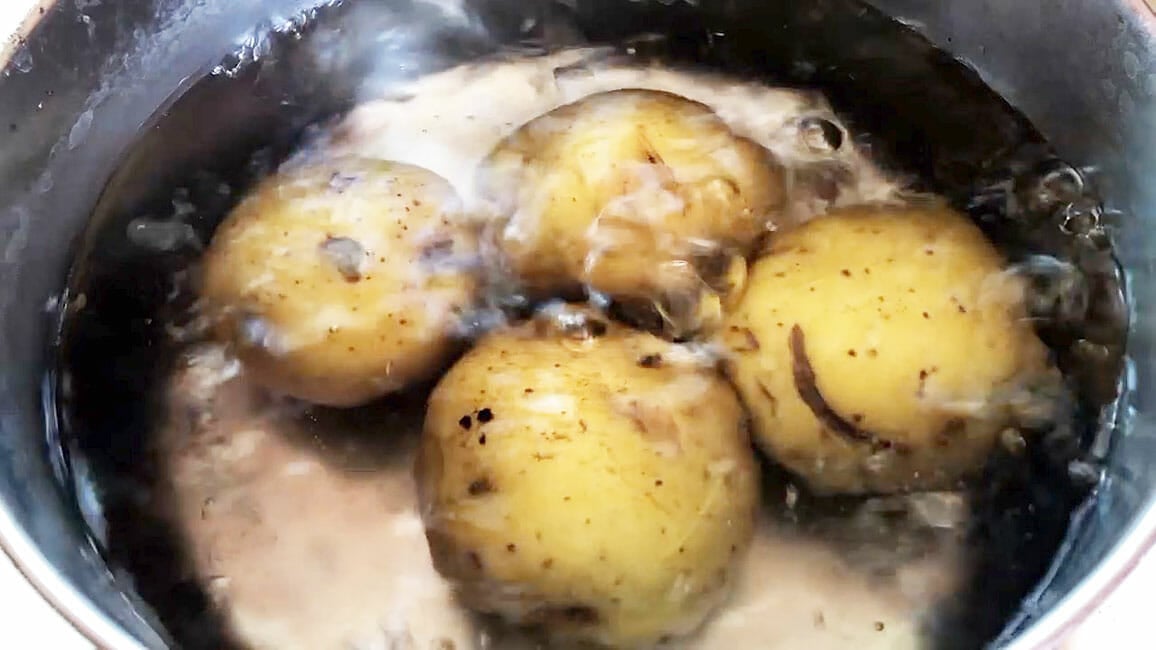 Yukon Gold potatoes boiling in water.