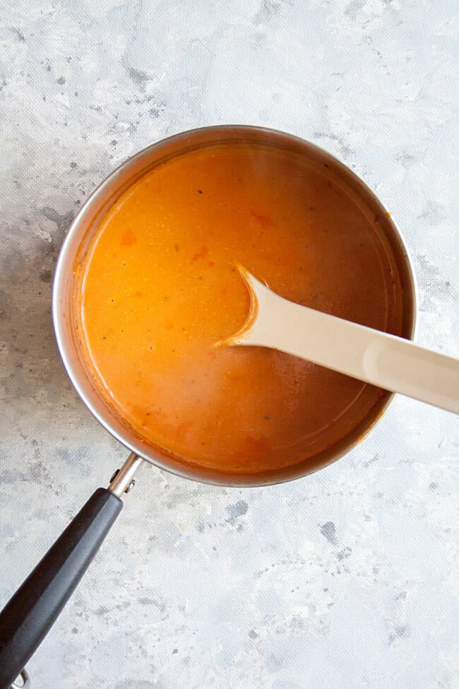 Healthy Tomato Soup in pan with spoon bird's eye view.