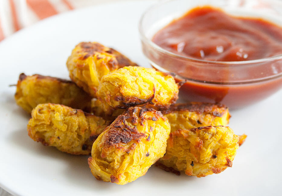 Tater Tots on plate with ketchup. 