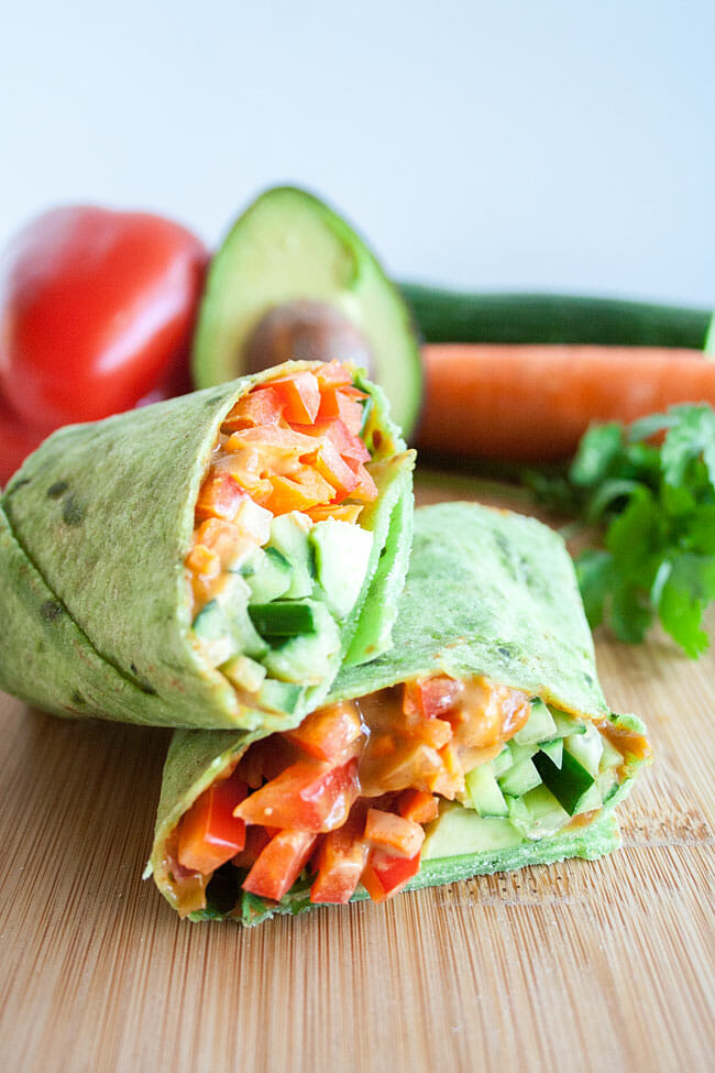 Thai Veggie Wrap cut in half on a cutting board.