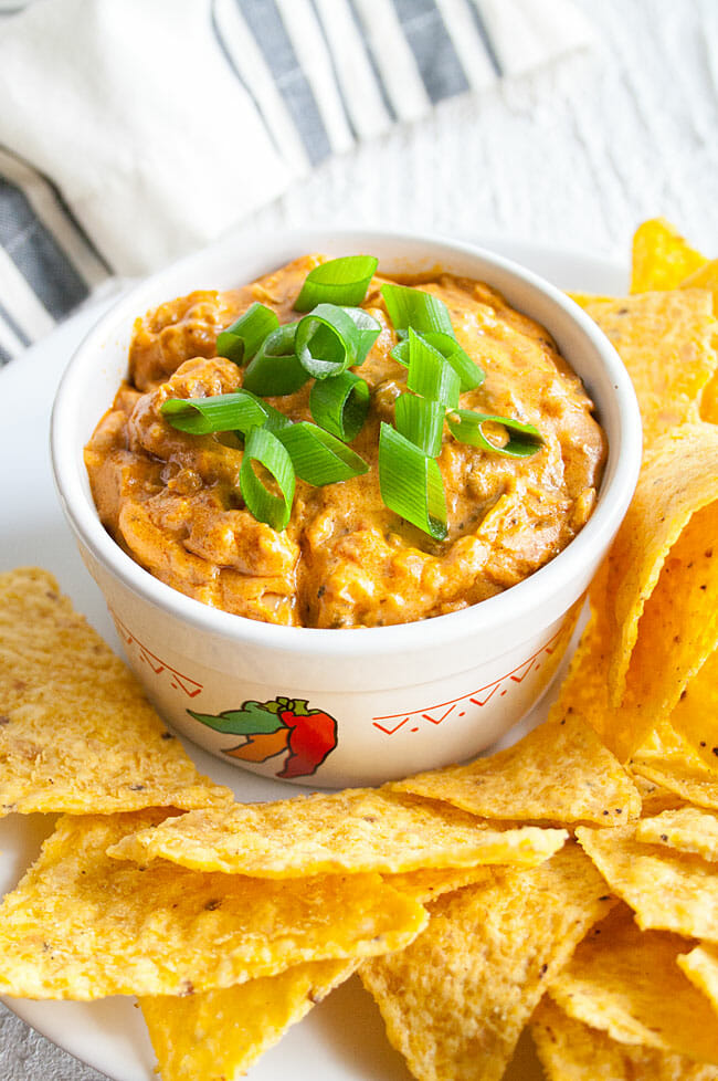 Vegan Cheese Dip with green onions and tortilla chips.