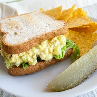 Tofu Salad Sandwich on a plate with a pickle.