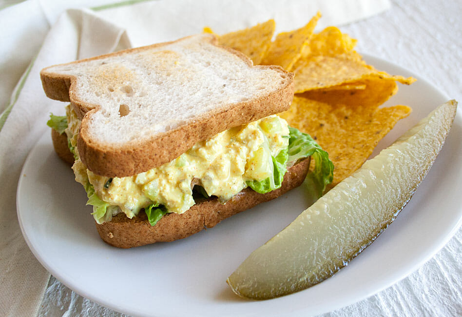 Tofu Salad Sandwich on a plate with a pickle.