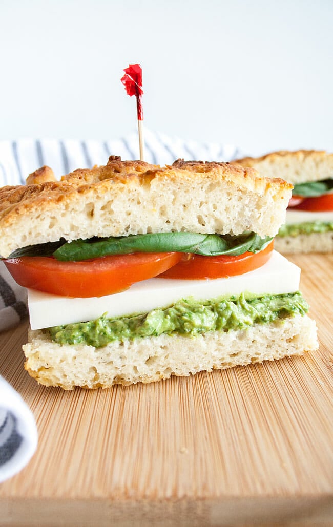  Vegan Avocado Pesto Caprese Sandwich on cutting board.
