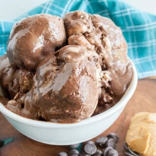 Chocolate Peanut Butter Ice Cream in a bowl with spoonful of peanut butter and chocolate chips next to it.