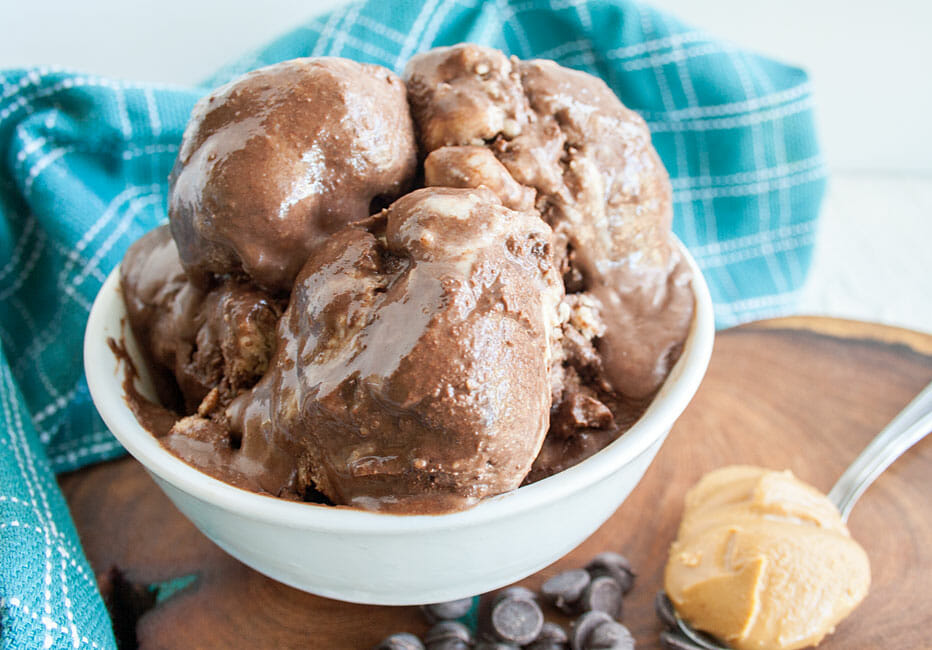 Chocolate Peanut Butter Ice Cream in a bowl with spoonful of peanut butter and chocolate chips next to it.