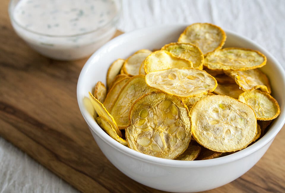 Squash Chips in a bowl with ranch dressing in background.