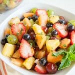 Rainbow Fruit Salad in a bowl with mint leaves.