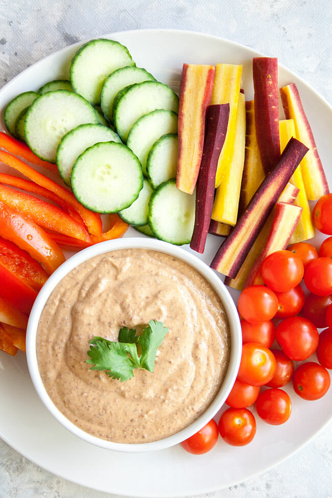Spicy Hummus with veggies on a plate bird's eye view.