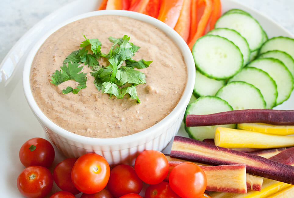 Spicy Black Bean Hummus on a plate with veggies.