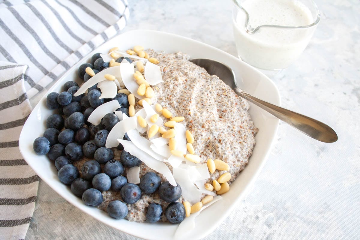 Spiced Chia Seed Porridge (vegan, gluten free, sugar free, keto) - This hearty breakfast is a a great way to start your day. It takes only minutes to make! #chiaseedporridge #veganketo #ketorecipes #ketobreakfast Spiced Chia Seed Porridge in a bowl with spoon.