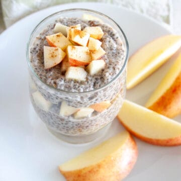 Apple Cinnamon Chia Pudding in a jar with sliced apples on a plate.
